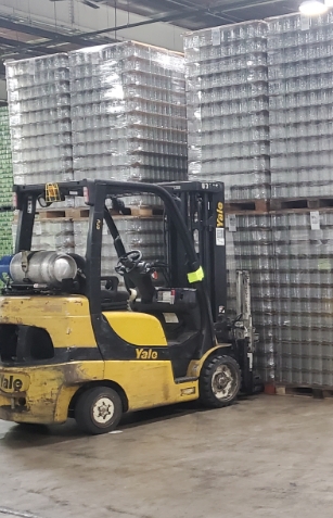 yellow forklift preparing to move items on pallet in warehouse