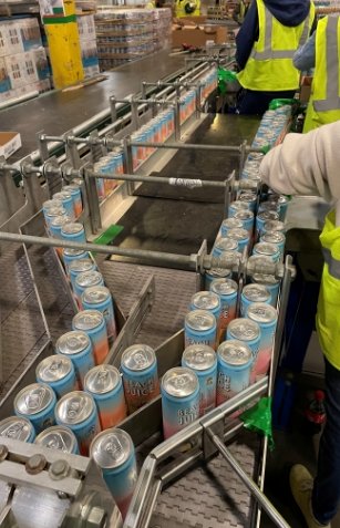 Canned drink products being manufactured on product line in warehouse