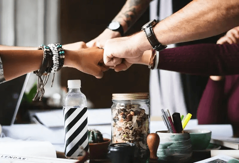 Employees putting their fists together in cooperation