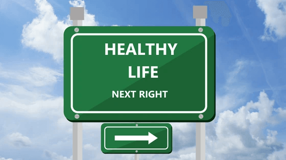 Green road sign that says "Health Life Next Right" with an arrow pointing to the right