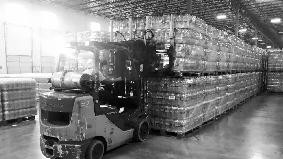 Forklift moving pallets of bottles in a Houston Warehouse