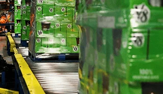 Wrapped pallets of V8 moving on a conveyer belt