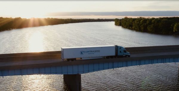 Truck from Keller Trucking crossing a bridge at sunrise