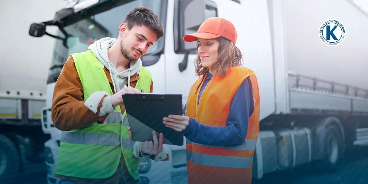 Two workers checking out information on a clipboard in front of a Keller Logistics truck.